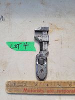 Full view of 4 inch metal adjustable wrench with ruler for scale showing length of about 4 inches.