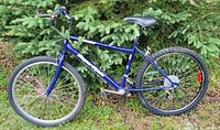 Side view of the blue Supercycle mountain bike showing frame, tires, seat, pedals, and gear setup.