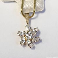 Close-up front view of the 10K yellow gold pendant with cubic zirconia stones arranged in a flower shape.