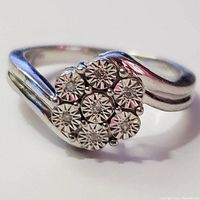 Close-up top view of the silver ring showing the 7 diamond cluster arrangement in floral pattern.