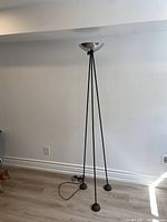Full view of tripod floor lamp showing overall structure, black legs, silver shade and cord placement
