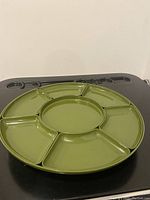 Top view of green lacquer Lazy Susan with six sectioned bowls arranged inside, showing round shape and glossy finish.