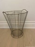 Full view of the vintage chrome wire hamper showing the conical shape and wire frame structure.