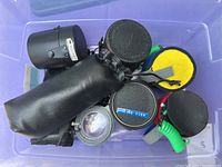 Four camera lenses packed together, showing black protective cases and lens covers.