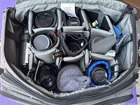 Open grey Tamrac gear bag with padded dividers holding multiple lenses, caps and accessories.