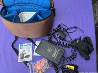 Quantum Turbo Battery unit and accessories spread out on a purple surface with carrying case open