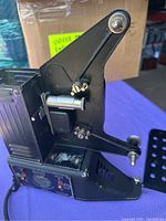 Overall side view of the Univex 8mm projector showing the reel arm and metal body.