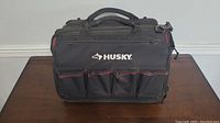 Front view of black Husky tool bag showing large pockets and logo