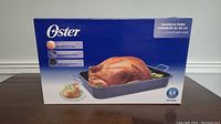 Photo of the boxed Oster 16 inch roasting pan showing package and brand logo