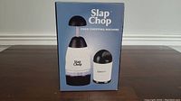 Original packaging of the Slap Chop food chopping machine and the smaller Graty unit shown from the front.