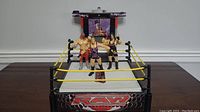 Full view of WWE RAW wrestling ring with three WWE action figures positioned inside the ring.