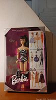 Full view of the 35th Anniversary Barbie doll in original packaging showing front damage to box and the doll wearing original striped swimsuit.