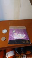 Photo of Winnipeg 100 coin, 5 pound coin damaged case and baby gift set coin sealed in purple packaging