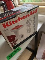 Photo of KitchenAid food grinder attachment in original box showing branding and product image on box.