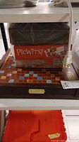 Unopened PicWits!, Villainous, Scrabble with wooden board visible under them