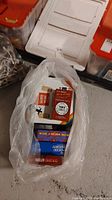 Photo of plastic bag containing multiple boxed card games stacked inside, showing edges of various game boxes.