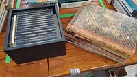 Photo showing marbled cover antique ledger or accounting books with worn leather spines adjacent to the advertising textbook set.