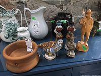 Photo of the handmade wood bowl alongside various figurines including Mexican pottery and a carved wooden figure.