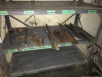 Shelf with crowbars, railway spikes, and wedges, showing arrangement and condition, labelled basement items