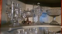Showing a variety of clear crystal and glass items including a candelabra, covered dish on metal base, and glass bowl.
