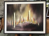 Full frontal view of abstract cityscape painting in black frame on stand