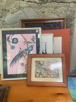 Two prints and three framed artworks arranged together showing bird print, historical scene print, and others