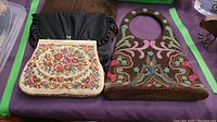 Four vintage purses displayed on table, showing detailed beadwork and embroidery