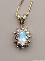 Close-up of oval moonstone pendant with diamond halo