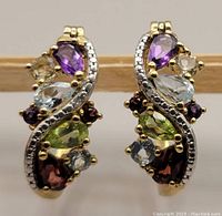 Close-up of the earrings showing multi-gemstones and gold-plated sterling silver swirl design