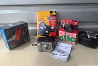 Lot contents showing various Canon and Kodak cameras, packaging, and accessories including camera case and manuals.