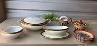 Full set of Noritake and multi-patterned Japan china including covered tureen, gravy boat, serving dishes, sugar bowl, creamer, and plates.