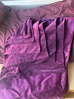 Purple comforter and matching shams laid out, showing fabric and color