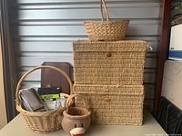 Full view of the lot showing large woven bins, two rattan baskets, monkey basket, body pillow cover, closet organizer, and wooden box with spoon holder