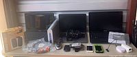 Overview of all items on a table including laptops, phones, printer, speakers, locks, and accessories