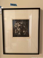Front view of framed lithograph showing full piece against wall