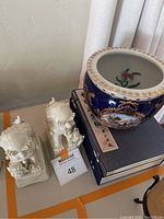 Overall shot of planter, foo dogs, art books on table
