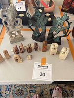 Overhead shot of all lot items on table: two bookends, goddess statue, eleven seal stamps