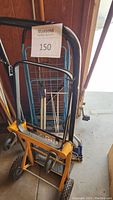 Three folding carts visible including yellow hand cart with black handles, blue wire basket cart, and third foldable cart.