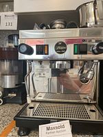 Front view of espresso machine showing control panel, drip tray and portafilter attachments on top