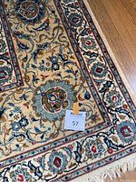 Close-up of field and border showing floral medallion motif and fringe edge