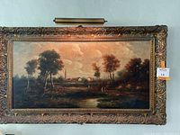 Front view of the oil painting in its ornate gilt frame with picture lamp attached