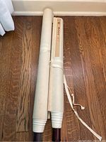 Two scrolls rolled up, one with exterior protective paper and decorative label, wood rollers visible