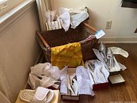 Overview of wicker basket with tissue paper, scarf and surrounding shoe boxes.
