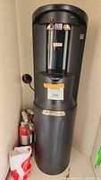 Front view of black bottom-loading water dispenser with hot and cold taps