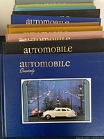 Photo showing a stack of 11 hardcover Automobile Quarterly books with various colored spines and covers, confirming edition years between 1977 and 1981.