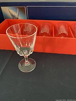 One crystal wine glass outside the box showing detailed cut pattern and stem shape. The glass is clear and faceted.