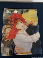 Front cover of the art book showing a Renoir painting of a couple dancing, with detailed color print.