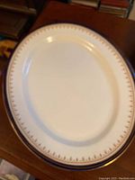 Oval Aynsley Leighton Cobalt china serving platter with decorative gold trim on wooden surface.