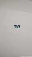 Two deep blue rectangular cut London Blue Topaz gemstones displayed on a plain surface.