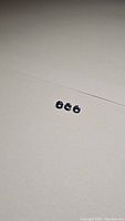 Three natural diamond cut tanzanite stones laid on white surface showing size and color